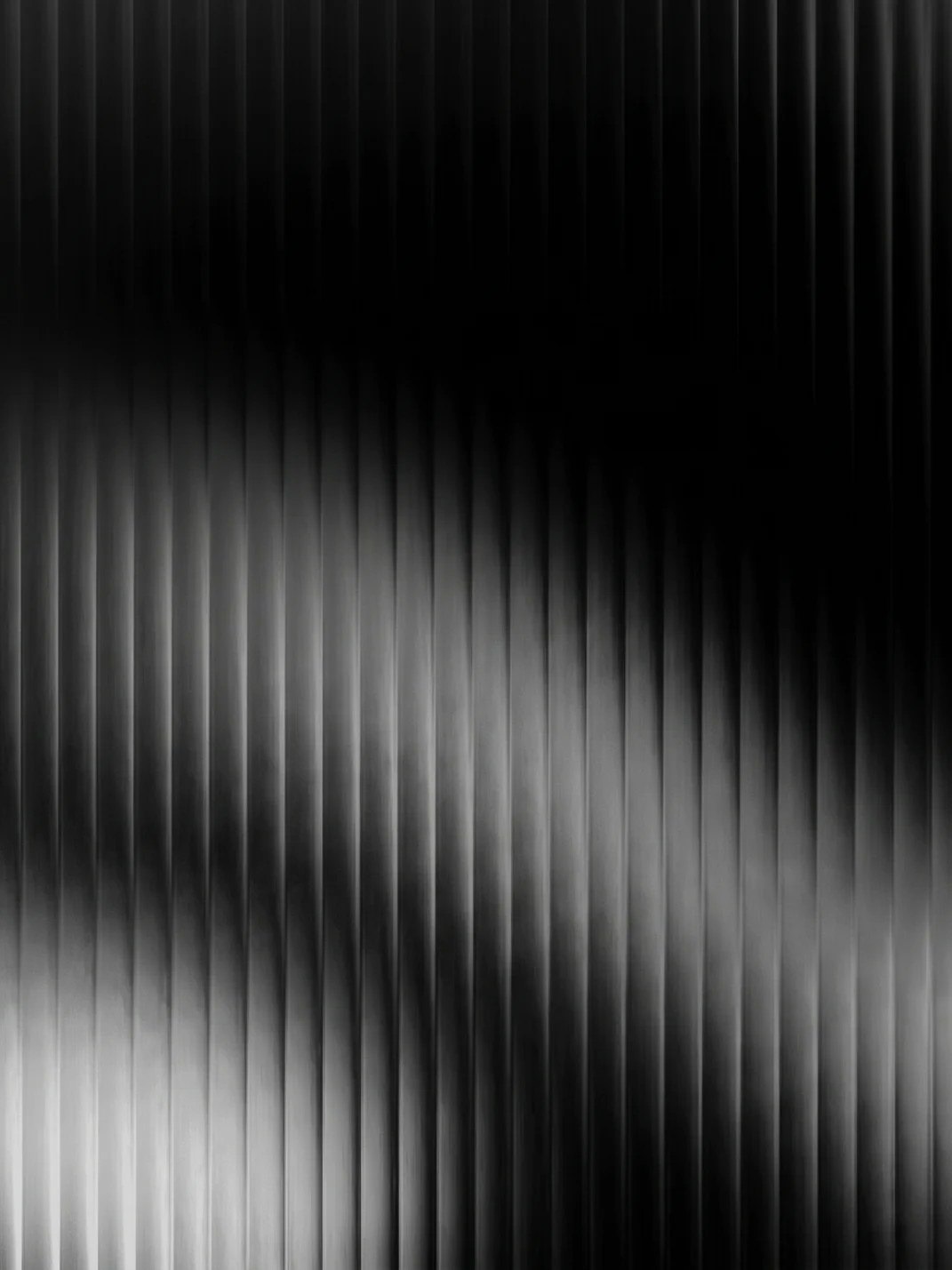 Fine vertical light running across a dark surface