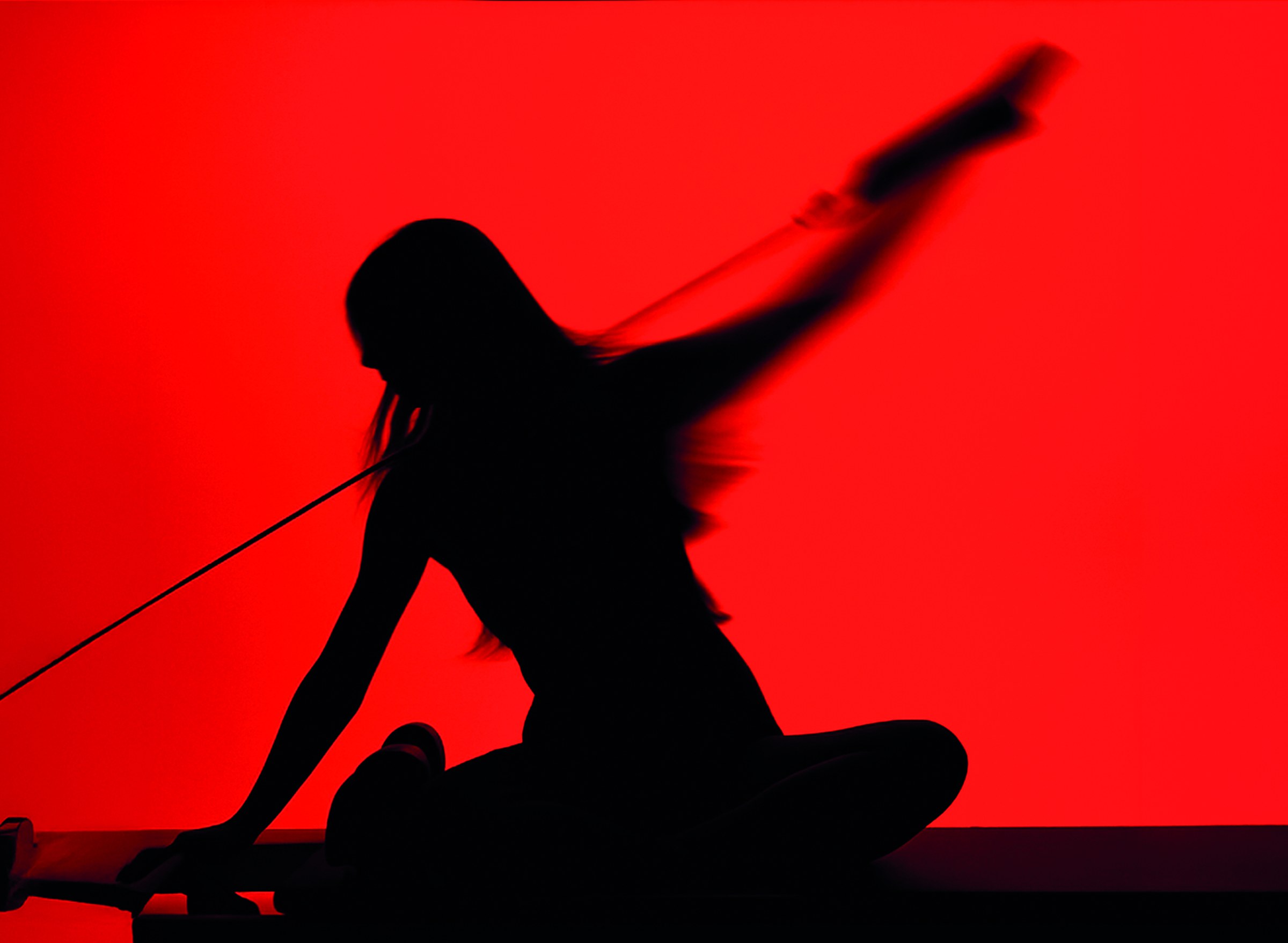A figure stretching with a resistance band against a red ground